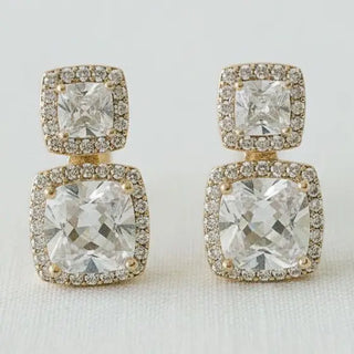 Double cushion-cut CZ halo drop earrings gold tone - close-up front view on white linen