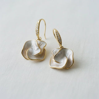 Mother-of-pearl camellia flower dangle earrings - angled side view on white background