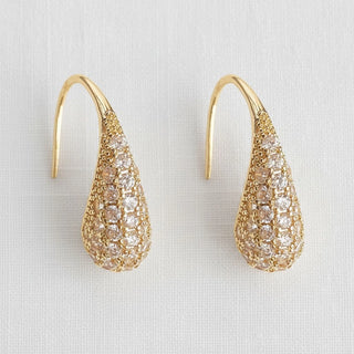 Gold pavé cubic zirconia teardrop dangle earrings - front view on white linen background