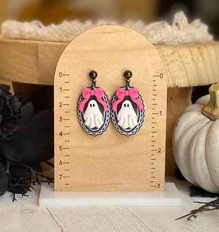 Halloween ghost earrings with a bright pink bow and ornate oval frame