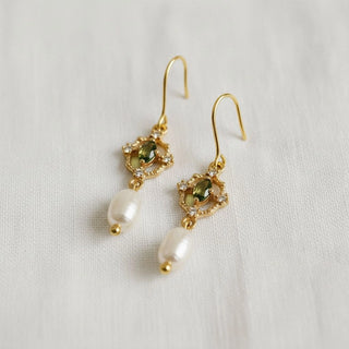 Green gemstone and freshwater pearl drop earrings - angled side view on white linen