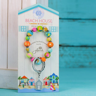 Beach House wrist keychain on display card propped against white shiplap with teal background