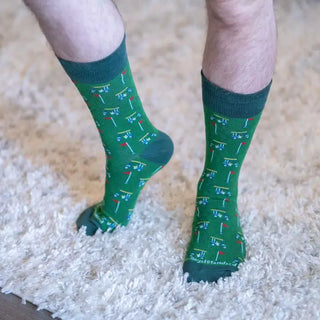 Men's green golf socks with miniature golf carts and red flags, featuring darker contrasting cuffs, heels, and toes