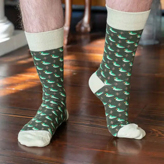 Men's hunter green socks with repeating green-and-white ducks and light contrasting cuffs, heels, and toes, shown worn