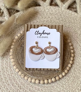 White coffee cup polymer clay dangle earrings with brown coffee, white heart latte-art details, and gold-tone round tops