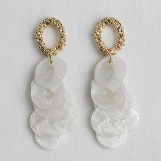 Mother-of-pearl disc tassel drop earrings with gold textured oval stud - flat lay front view