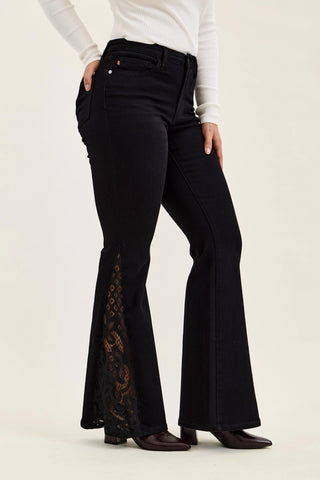 Model wearing black Judy Blue Jaqueline ultra flare jeans with lace inserts at the hem.