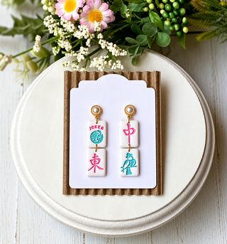 White double-tile statement earrings with pink, teal, red, and blue mahjong-inspired designs