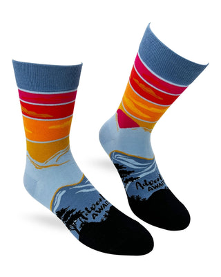 Pair of Adventure Awaits men's crew socks with red, orange, and golden sunset bands, blue mountains, black trees, and black toes