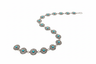 Western silver concho link belt with turquoise stones on white studio background