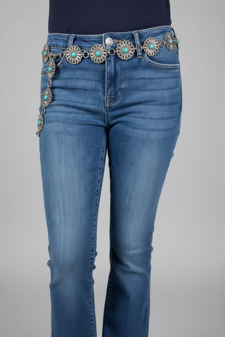 Western silver concho link belt with turquoise stones worn on medium wash blue denim jeans