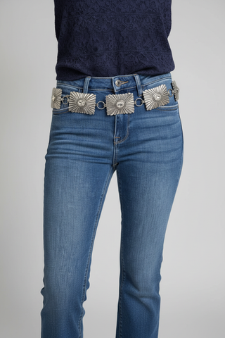 Western silver sunflower concho belt with crystal centers worn on medium wash blue denim jeans